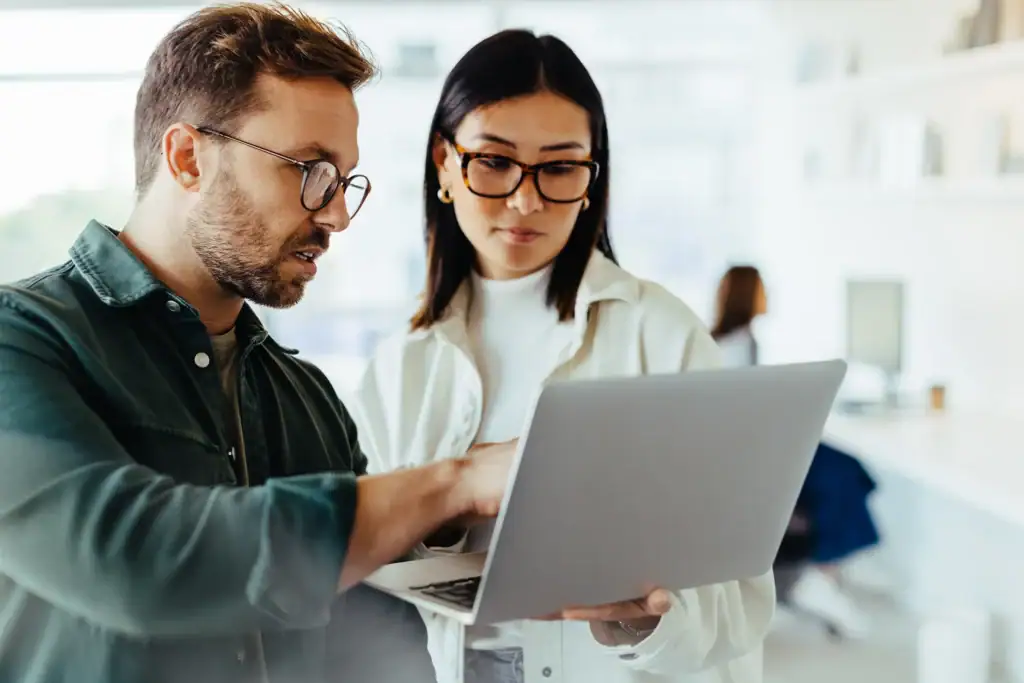 Two people looking at a laptop together.