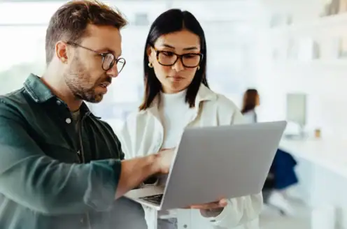 Two people looking at a laptop together.
