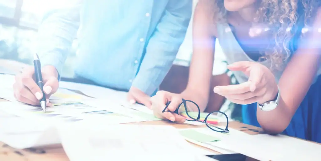 Two people examining printed documents together.