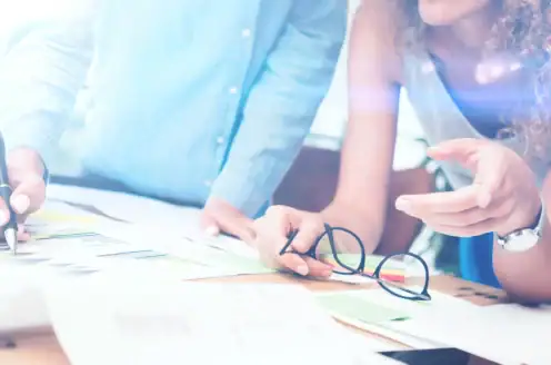 Two people examining printed documents together.